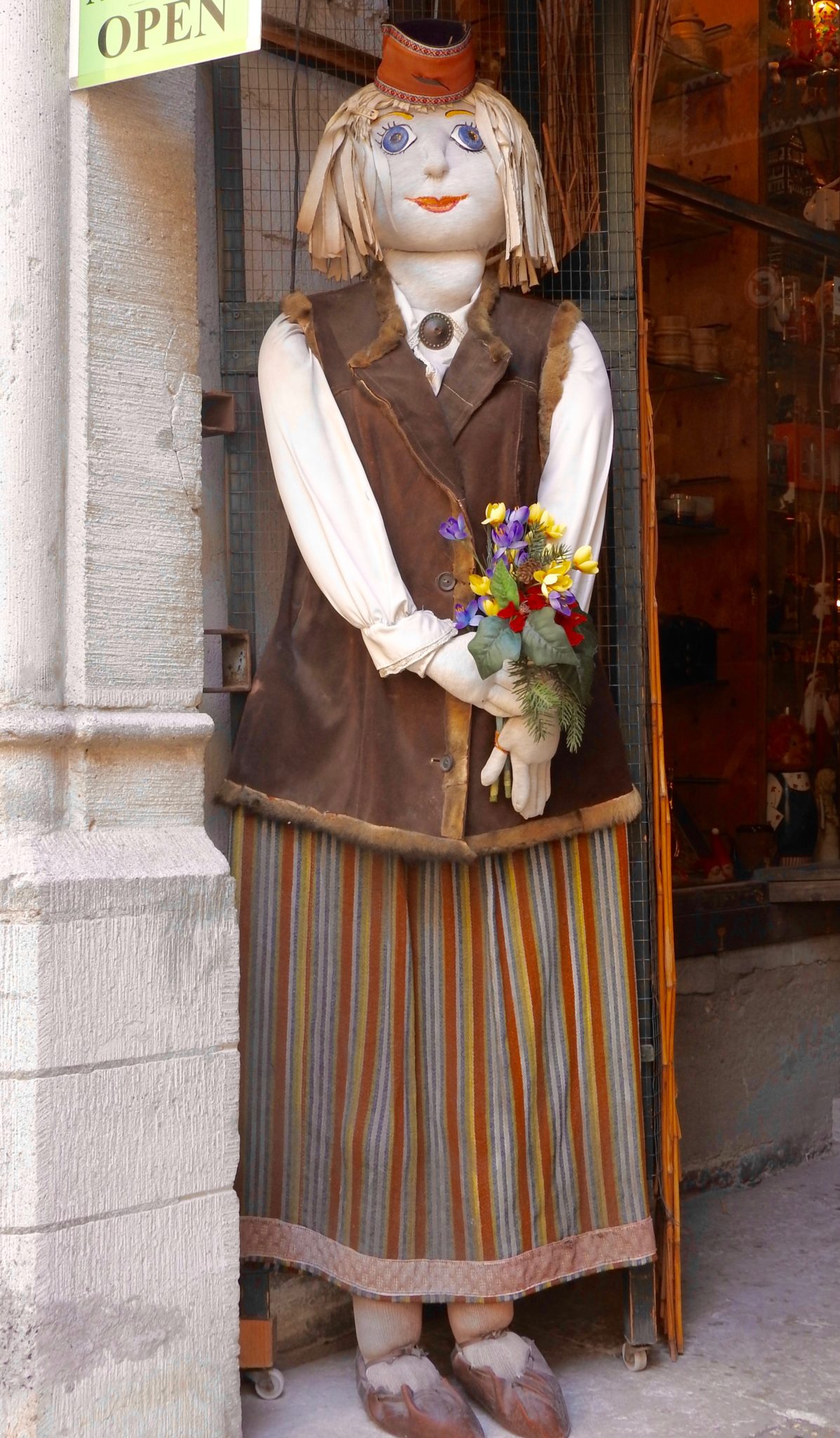 Door Doll in brown jacket and striped skirt, Tallinn shopfront