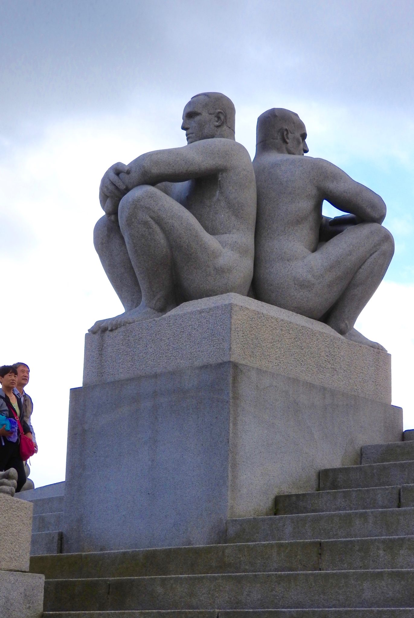 Granite statues of men sitting back to back