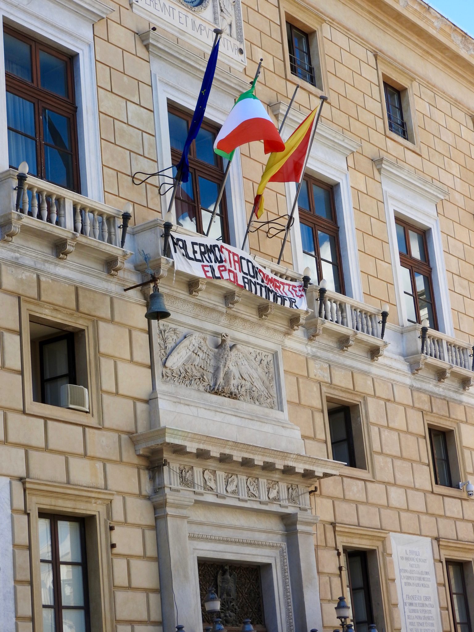 Yellow brick building with flags and banner