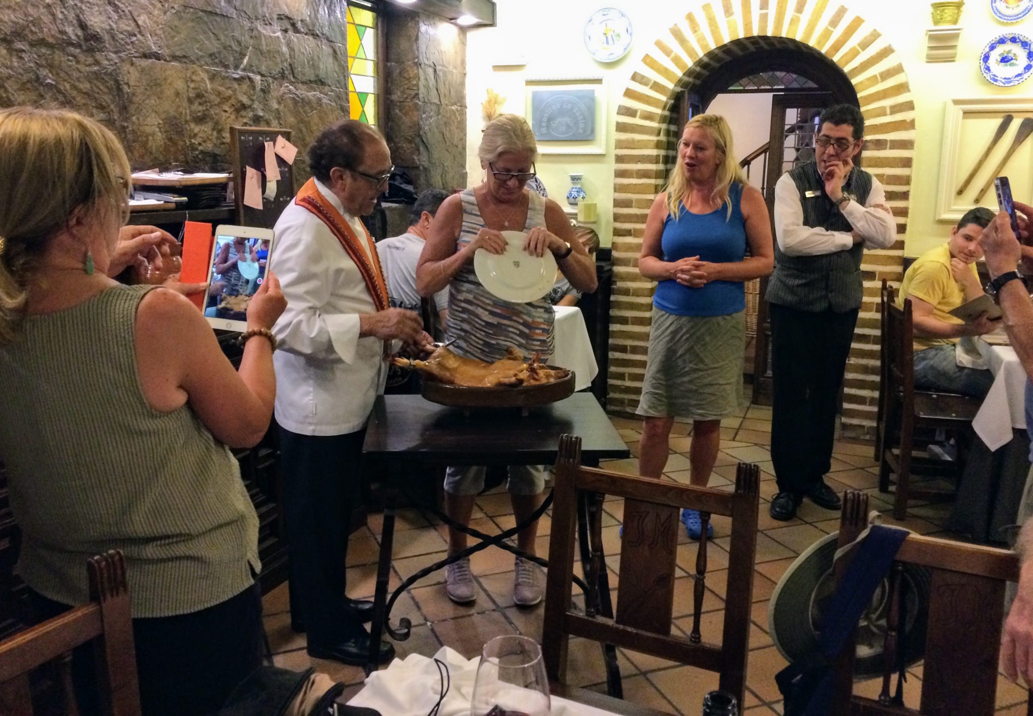 Carving the suckling pig, with a plate people watch as suckling pig is carved with plate