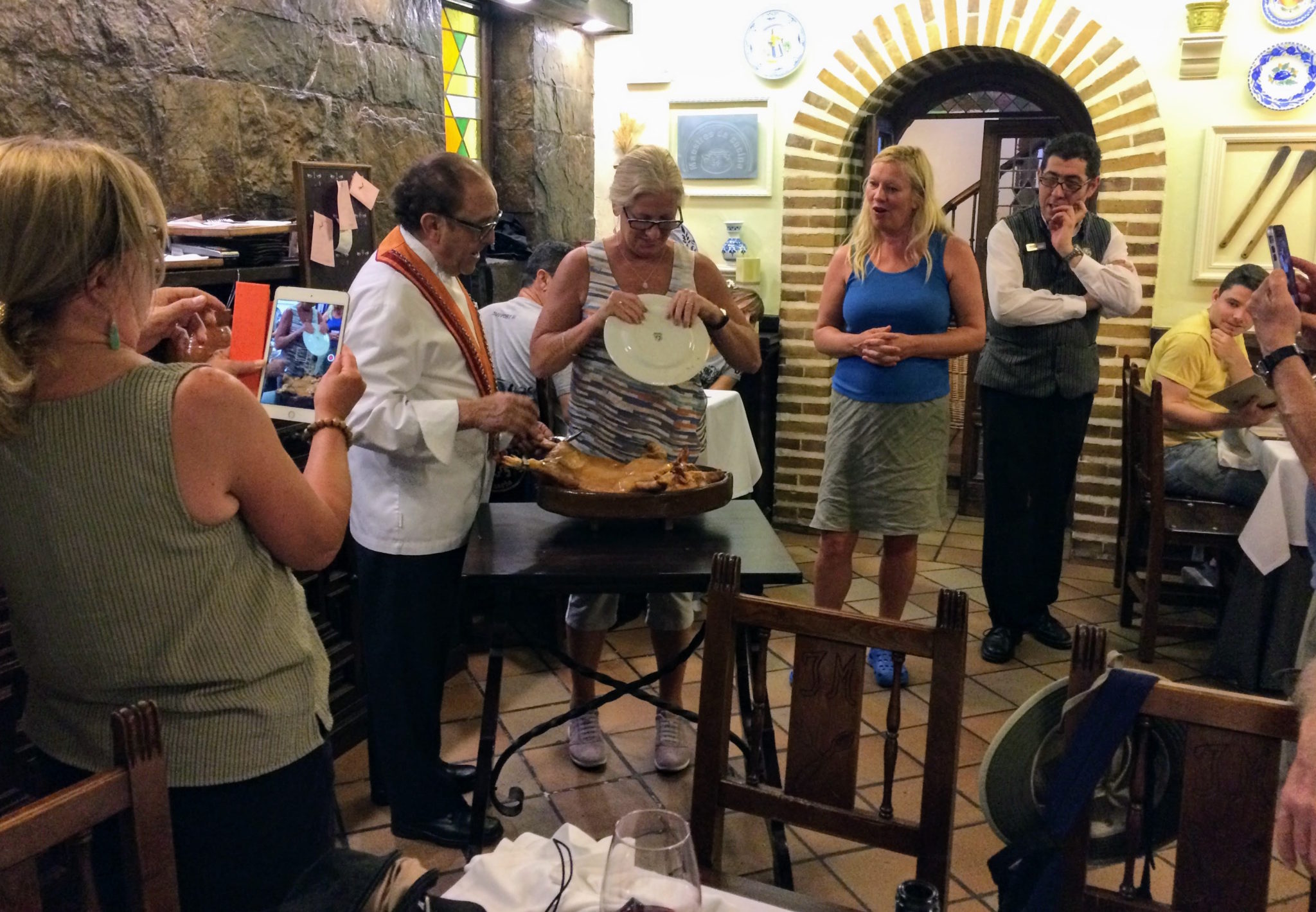 people watch as suckling pig is carved with plate