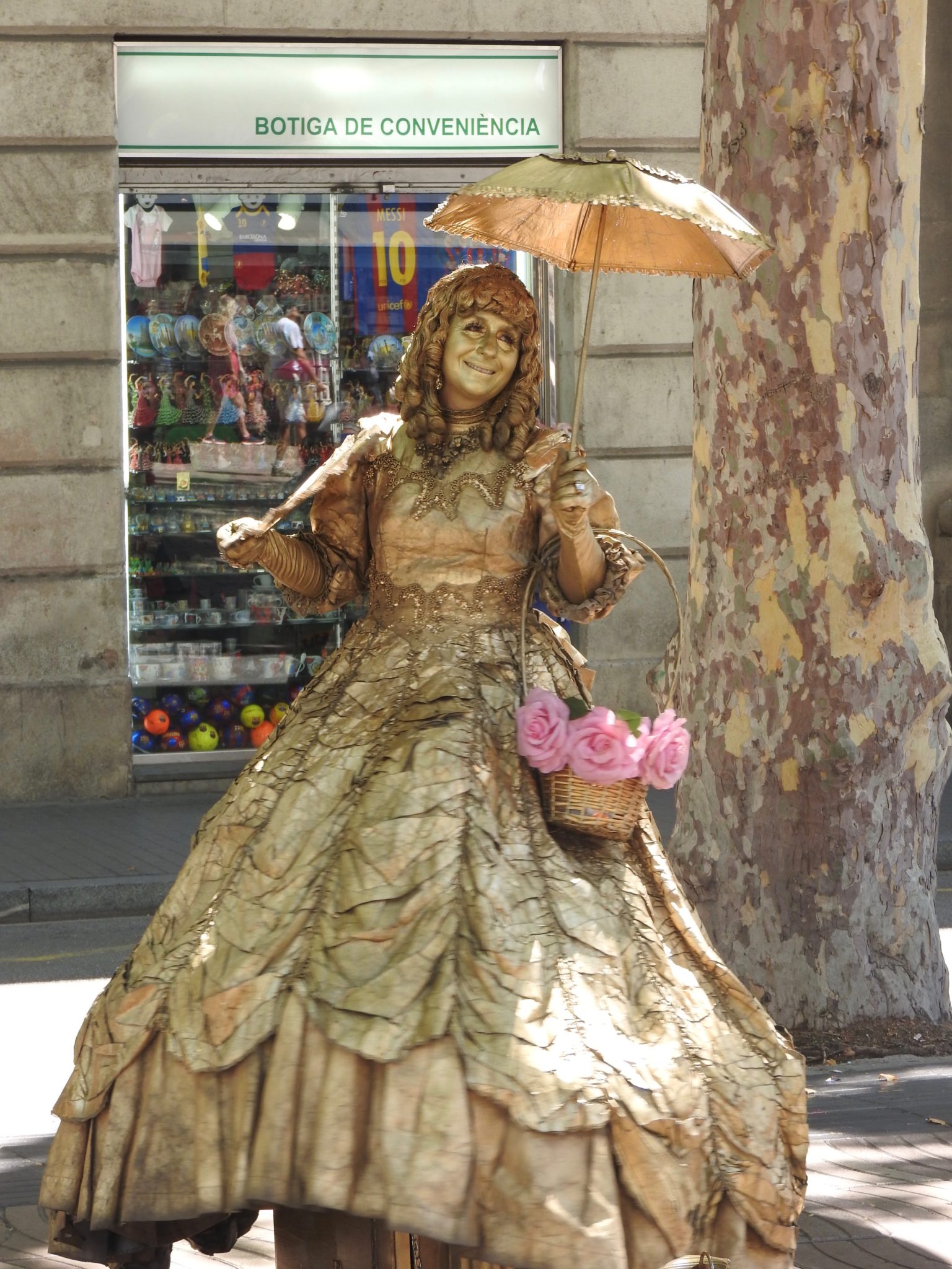 Street performer in gold make up and hoop skirt